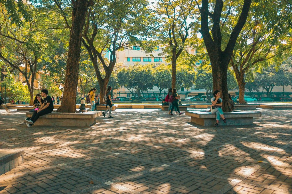 Students relaxing on a sunlit university campus plaza