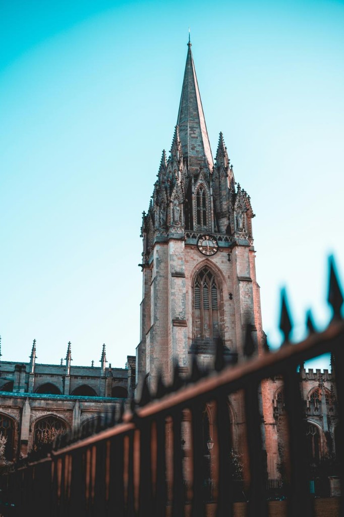 Gothic university tower against a clear blue sky